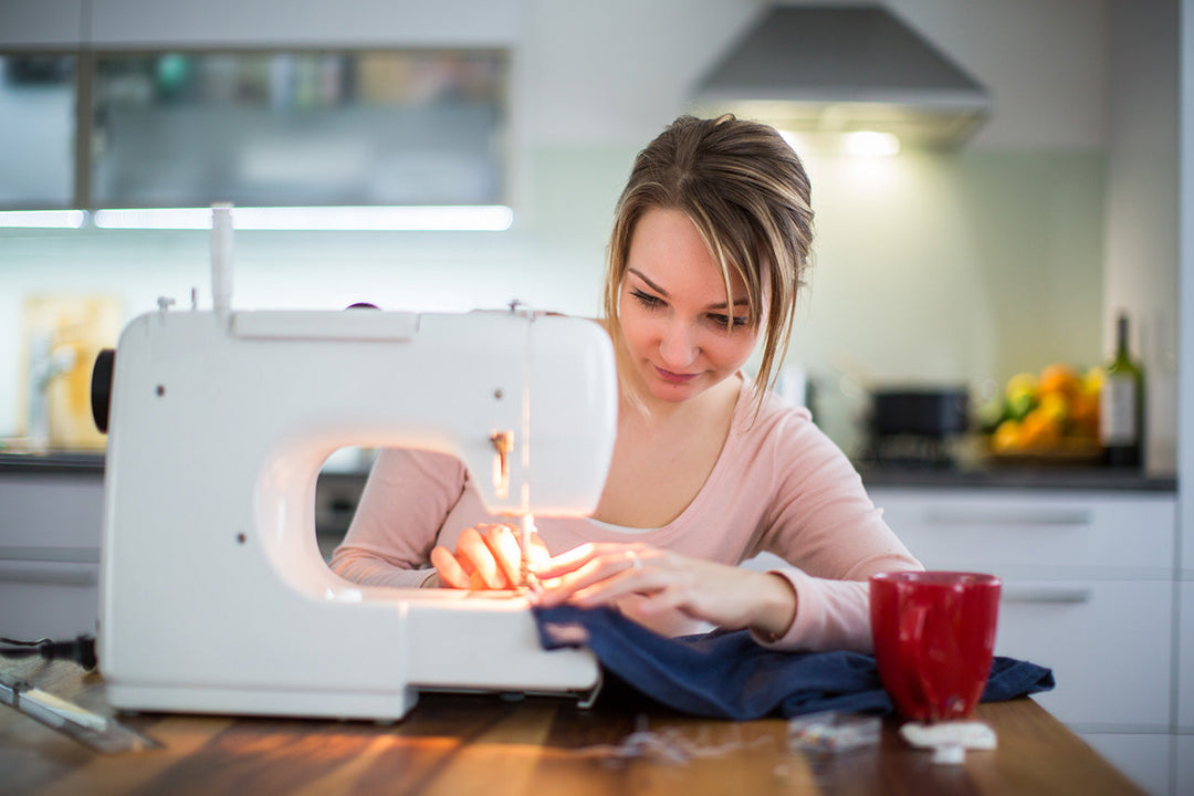 Young woman making clothes with sewing machine