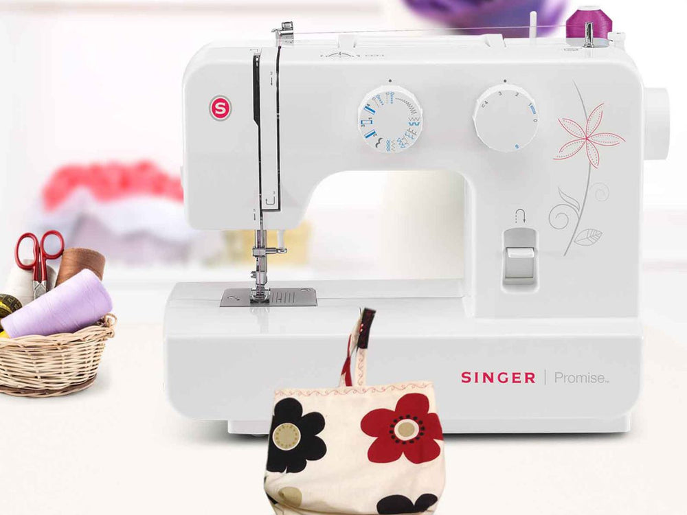 Singer sewing machine with a small floral-patterned bag on a white background