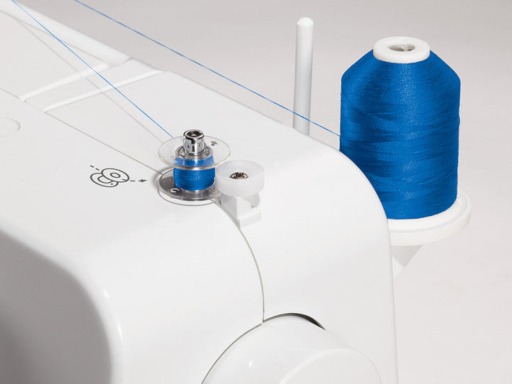 A zoomed in view of the bobbin winder with blue thread on the Singer Promise 1409 sewing machine.